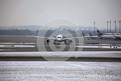 Planes at terminal gates in Munich Airport, winter time with snow Editorial Stock Photo